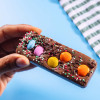 Small milk chocolate bar loaded with chocolate beans and colourful sprinkles.
