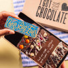 Hand holding a “Cheers Big Ears” chocolate bar above an open gift box of handmade bars – a fun way to say thanks with chocolate.
