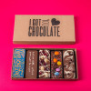 Brightly lit ‘I Got You Chocolate’ box showing five handmade chocolate bars with cheeky messages and tasty toppings – a playful thank you gift.