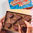 Bagstock & Bumble Inspirational Obnoxious Chocs being held up, filled with solid Belgian chocolate hearts – the ideal funny gift for friends.