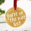 Shimmery gold chocolate stocking filler, hanging from a red ribbon and decorated with a You're on the nice list message