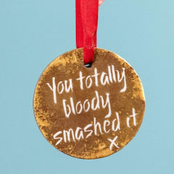 'You totally bloody smashed it' congratulations chocolate gold medal being held up with its red ribbon