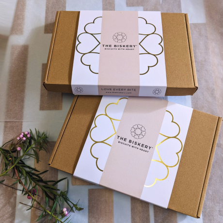 Boxes labelled 'The Biskery' and 'Love Every Bite' sit on a table, filled with Easter gift biscuits.