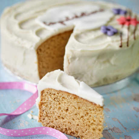 Banana cake with piped message and a slice removed to the side