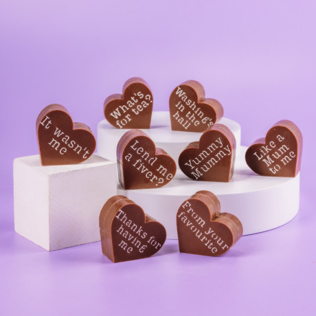 Cheeky selection of Bagstock & Bumble Mum chocolates displayed on plinths, showing off witty slogans like 'Like a Mum to me', designed to make mums smile.