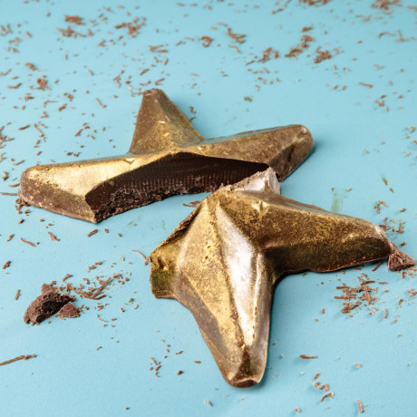 Broken gold chocolate star with shavings around it – a sweet and shiny gift to show you're proud.