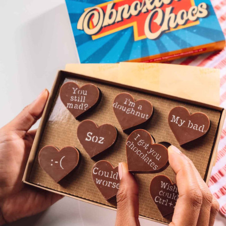 Bagstock & Bumble Sorry Obnoxious Chocs being held up, filled with Belgian chocolate hearts and cheeky slogans, the ideal funny sorry gift.