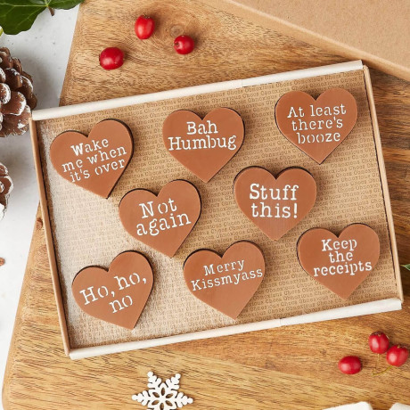 The Obnoxious Chocs funny Christmas gift for friends presented in their gift box. The slogans include: 'Wake me when it's over'; 'Bah Humbug'; 'At least there's booze'; 'Not again'; 'Stuff this!'; 'Ho, ho, no'; 'Merry Kissmyass'; and 'Keep the receipts'.
